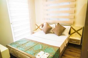 1 dormitorio con cama con almohadas y ventana en Ale Apartments Hotel, en Antalya