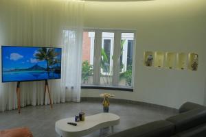 a living room with a couch and a flat screen tv at Biệt thự biển có bể bơi Sea Sing Villa in Nghi Xuân
