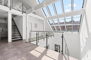a large white room with stairs and windows at VIVO Loft Frankfurt Flughafen mit Parkplatz in Kelsterbach +20 photos