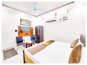 AyodhyaHOTEL SHREE MATESHWARI # PALACE Near Ramjanambhoomi - Shri Hanuman Garhi Mandir 800M & Ayodhya Dham Junction Railway Station - Fully Air Conditioning Rooms - Free Wifi & Parking Facilities - Excellent Customer Service的一间卧室，配有一张床、一张桌子和一把椅子