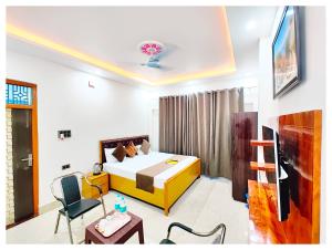 AyodhyaHOTEL SHREE MATESHWARI # PALACE Near Ramjanambhoomi - Shri Hanuman Garhi Mandir 800M & Ayodhya Dham Junction Railway Station - Fully Air Conditioning Rooms - Free Wifi & Parking Facilities - Excellent Customer Service的一间带床、桌椅的酒店房间
