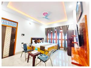 AyodhyaHOTEL SHREE MATESHWARI # PALACE Near Ramjanambhoomi - Shri Hanuman Garhi Mandir 800M & Ayodhya Dham Junction Railway Station - Fully Air Conditioning Rooms - Free Wifi & Parking Facilities - Excellent Customer Service的一间带床、桌椅的酒店房间