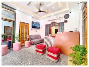 AyodhyaHOTEL SHREE MATESHWARI # PALACE Near Ramjanambhoomi - Shri Hanuman Garhi Mandir 800M & Ayodhya Dham Junction Railway Station - Fully Air Conditioning Rooms - Free Wifi & Parking Facilities - Excellent Customer Service的客厅里摆放着粉色凳子和椅子