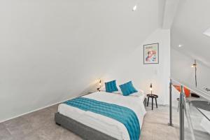 a white bedroom with a bed with blue pillows at VIVO Loft Frankfurt Flughafen mit Parkplatz in Kelsterbach