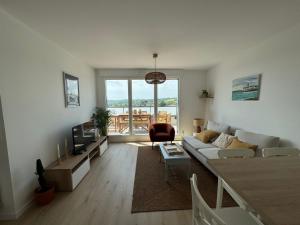 a living room with a couch and a tv at Appartement Le Riva B304 in Barneville-Carteret