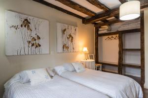 a bedroom with two beds and two paintings on the wall at Complejo Abiada Rural in Abiada