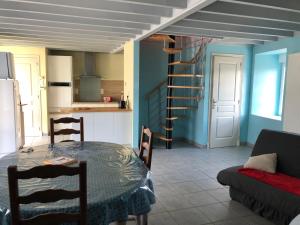 cocina y comedor con mesa y sofá en Gîte le Laurier, en Saint-James