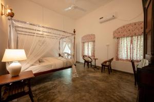 a bedroom with a bed with a mosquito net at Southwinds, Pilagoda Estate Bungalow in Pillagoda +26 photos