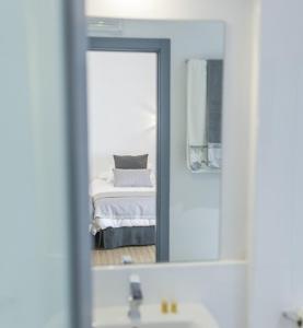 a bathroom mirror with a bed in the reflection of a bedroom at Casa Rural Castillo de Cáceres in Cáceres