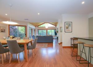 a dining room and living room with a table and chairs at On The Trail in Bright