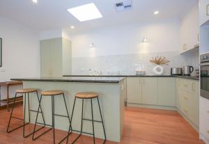 a kitchen with a large island with stools at On The Trail in Bright +26 photos