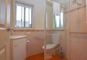 a bathroom with a toilet and a glass shower at On The Trail in Bright
