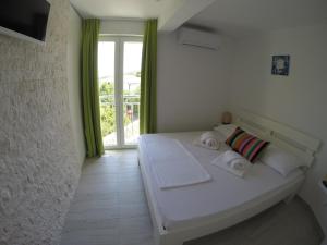 1 dormitorio con cama blanca y ventana en Villa Zara, en Trogir