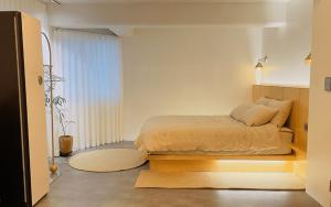 a bedroom with a bed and a large window at Jeju Arpore Stay in Jeju