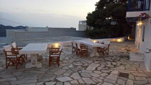 a group of tables and chairs on a stone patio at Piazza Castello in Plaka Milou