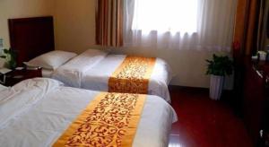 a hotel room with two beds and a window at GreenTree Inn Shanghai South Railway Station Xujiahui Stadium Subway Station Shell Hotel in Shanghai