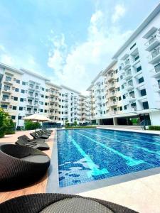 a swimming pool in front of a large apartment building at Hills Residences by JuJu Staycation in Manila