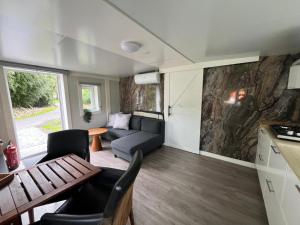 a caravan living room with a couch and a table at Zwart Pareltje in Kiel