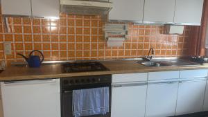 a kitchen with white cabinets and a stove top oven at Ferienwohnung in Wirges in Wirges +5 photos