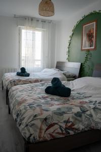 zwei Betten mit Handtüchern in einem Schlafzimmer in der Unterkunft Chaleureux T3 aux pieds du Stade de France in Saint-Denis