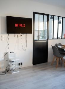 ein Schild, das Netflix an einer Wand in einem Raum liest in der Unterkunft Chaleureux T3 aux pieds du Stade de France in Saint-Denis