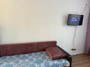 a room with a couch and a tv on the wall at Promenade Burabay 2 in Borovoye +1 photo