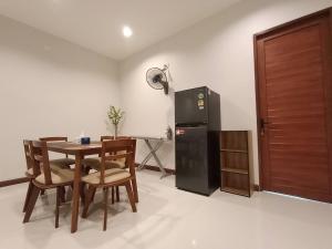 Ban Khlong WaにあるDeecozyのテーブルと冷蔵庫のあるダイニングルーム