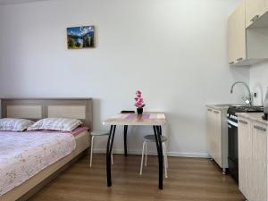 a small bedroom with a bed and a table at Promenade Burabay 2 in Borovoye