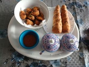 a plate with food and a bowl of dipping sauce at Fog & Fern in Kurseong