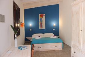 San Gregorio的住宿－La Fattoria Delle Tartarughe，一间卧室设有一张床和蓝色的墙壁