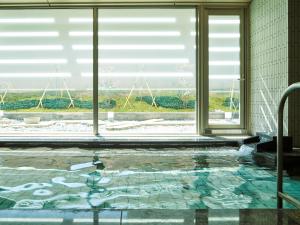 a swimming pool in a building with a window at Mitsui Garden Hotel Kyoto Shijo in Kyoto