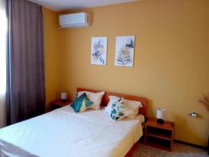 a bedroom with a bed with white sheets and pillows at Solis in Primorsko