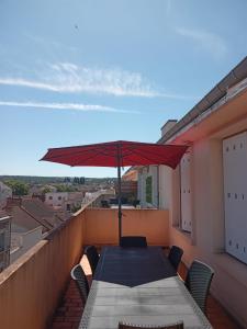 a table with an umbrella on top of a balcony at Appartement spacieux au centre-ville in Montluçon