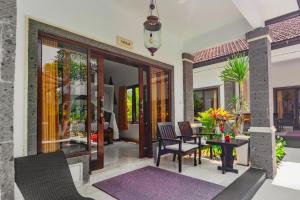 a patio with a table and chairs in a house at Balam Bali Villa in Mengwi