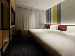 a hotel room with a large bed and a television at Mitsui Garden Hotel Kyoto Shijo in Kyoto