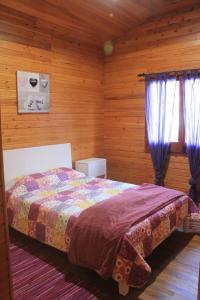 1 dormitorio con 1 cama en una habitación de madera en Casa dos Manos, en Furnas