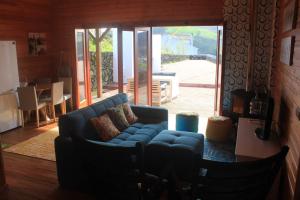 a living room with a blue couch and a table at Casa dos Manos in Furnas