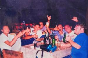 a group of men sitting at a table with their drinks at Pondok Sedi Bungalow in Labuhancari