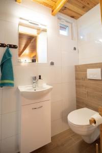 a bathroom with a white toilet and a sink at Domek we Władku in Władysławowo +24 photos