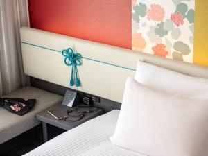 a hotel room with a bed with a bow on the headboard at Mitsui Garden Hotel Kyoto Shijo in Kyoto