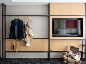 a living room with a tv and a wooden cabinet at Mitsui Garden Hotel Kyoto Shijo in Kyoto