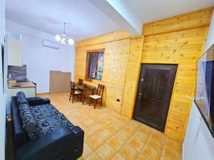 a living room with a black couch and a table at Homestay Beauty Day in Durrës