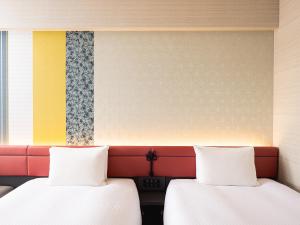 two beds sitting next to each other in a room at Mitsui Garden Hotel Kyoto Shijo in Kyoto