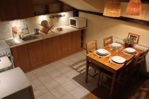 cocina con mesa de madera con sillas y fregadero en 4Party, en Cracovia