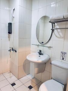 a bathroom with a toilet and a sink and a mirror at Tomorrow Hotel in Taipei