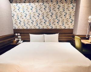 a bedroom with a large white bed in a room at Tomorrow Hotel in Taipei
