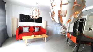 a living room with a red couch and a table at Casa Rincón Medanero in El Médano