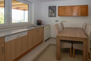 a kitchen with a wooden table and a sink at Ferienwohnung Weitblick nahe Göttingen in Hardegsen