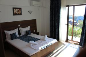 a bedroom with a bed with towels on it at Vila Medeea in Costinesti