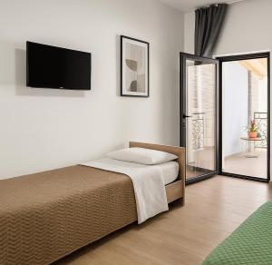 a bedroom with a bed and a flat screen tv at B&B La Casetta di Cecè in Celano